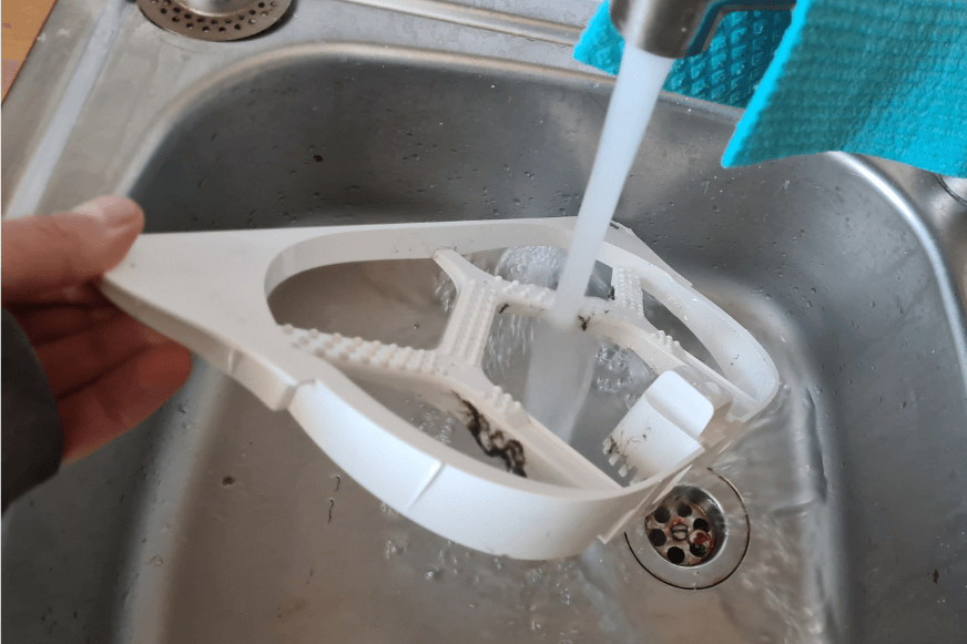 Die Noppenplatte der Dreame L10s Ultra Basisstation wird unter fließendem Wasser gereinigt.